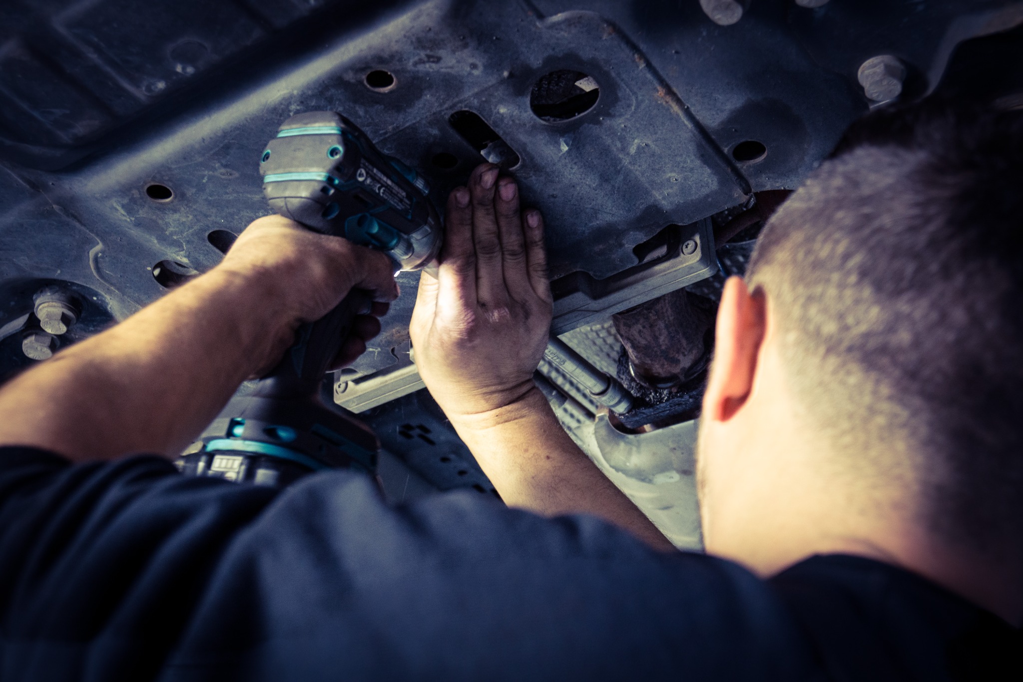 Mechaniker bei Arbeiten unter einem Fahrzeug