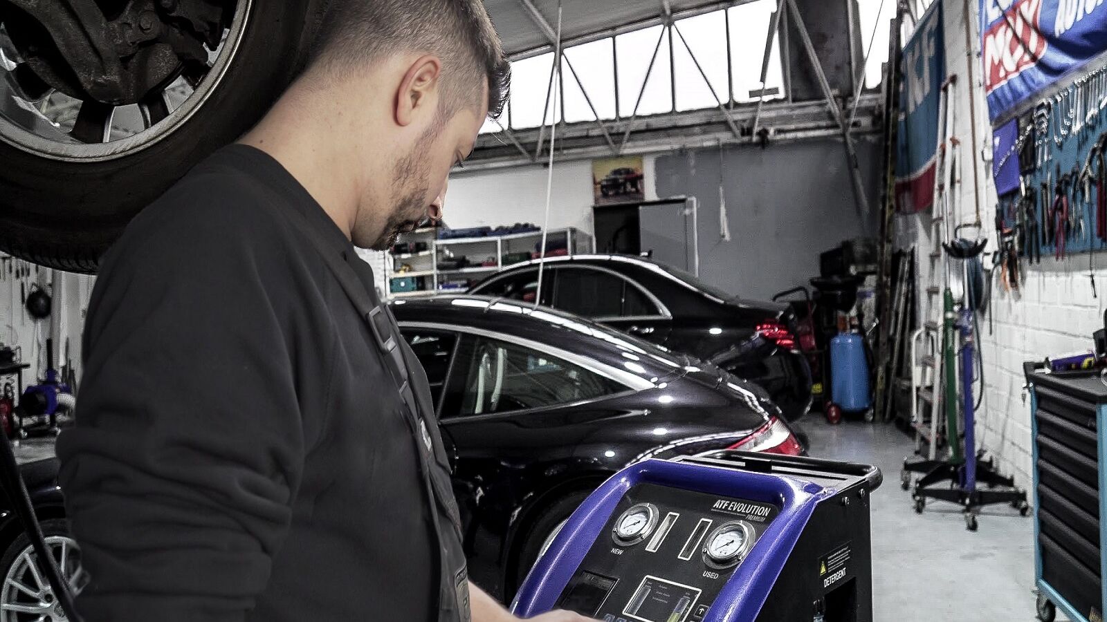 KFZ-Mechaniker bedient ein Ger&auml;t zur automatischen Getriebesp&uuml;lung in der Werkstatt.